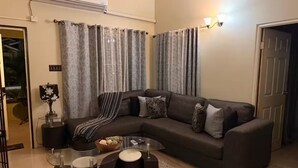 A living room with a sectional sofa, a glass coffee table, and a dark rug. - Sumfest ~ Draxhall ~ 24hr Gated ~ Pool (St Ann Jamaica)
