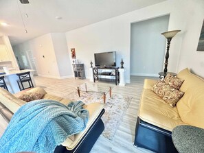 Ein Wohnzimmer mit einer Couch, einem Couchtisch und einem Fernseher.