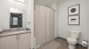 A modern bathroom with a shower, toilet, and sink. - Walk to the Brickyard 400! 2BR/2BA Apartment in Speedway, IN! (Speedway)