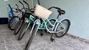 Biciclette appoggiate a un muro con superficie strutturata.