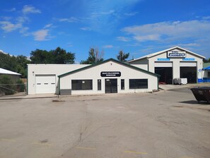 A building with a sign for 'Black Hills Bunkhouse' and another sign for 'SME Alignment Auto Repair'. - Black Hills Barking Bunkhouse - Remodeled bldg with all amenities and 3 RV sites (Belle Fourche)