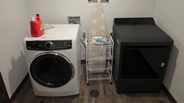 A laundry area with a washing machine, an iron, and a dryer. - Black Hills Barking Bunkhouse - Remodeled bldg with all amenities and 3 RV sites (Belle Fourche)
