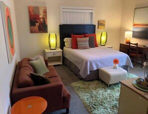 Une chambre d’hôtel avec un lit, un canapé, un bureau et une chaise.