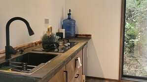 Eine moderne Küche mit Holzboden, einem großen Fenster und einem Wasserspender.