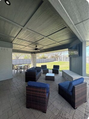 An outdoor covered patio with wicker furniture and a ceiling fan. - Cozy 2 bedroom home close to downtown Frisco! Enjoy all that Frisco has to offer (Frisco)