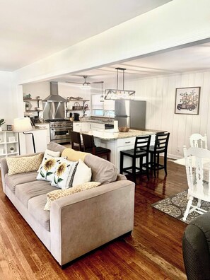 A modern kitchen with stainless steel appliances, a dining area with a white table and chairs, and a living room with a sofa and decorative pillows. - Near McLeod & Downtown · Sleeps 6 · Free WiFi (Florence)