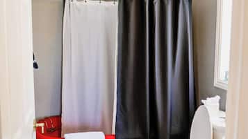 A bathroom with a toilet, a sink, a shower curtain, and a towel rack.