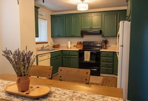 A kitchen with green cabinets, a stove, and a refrigerator. - A magical cabin located in -The "Gateway to Yosemite" (Groveland)