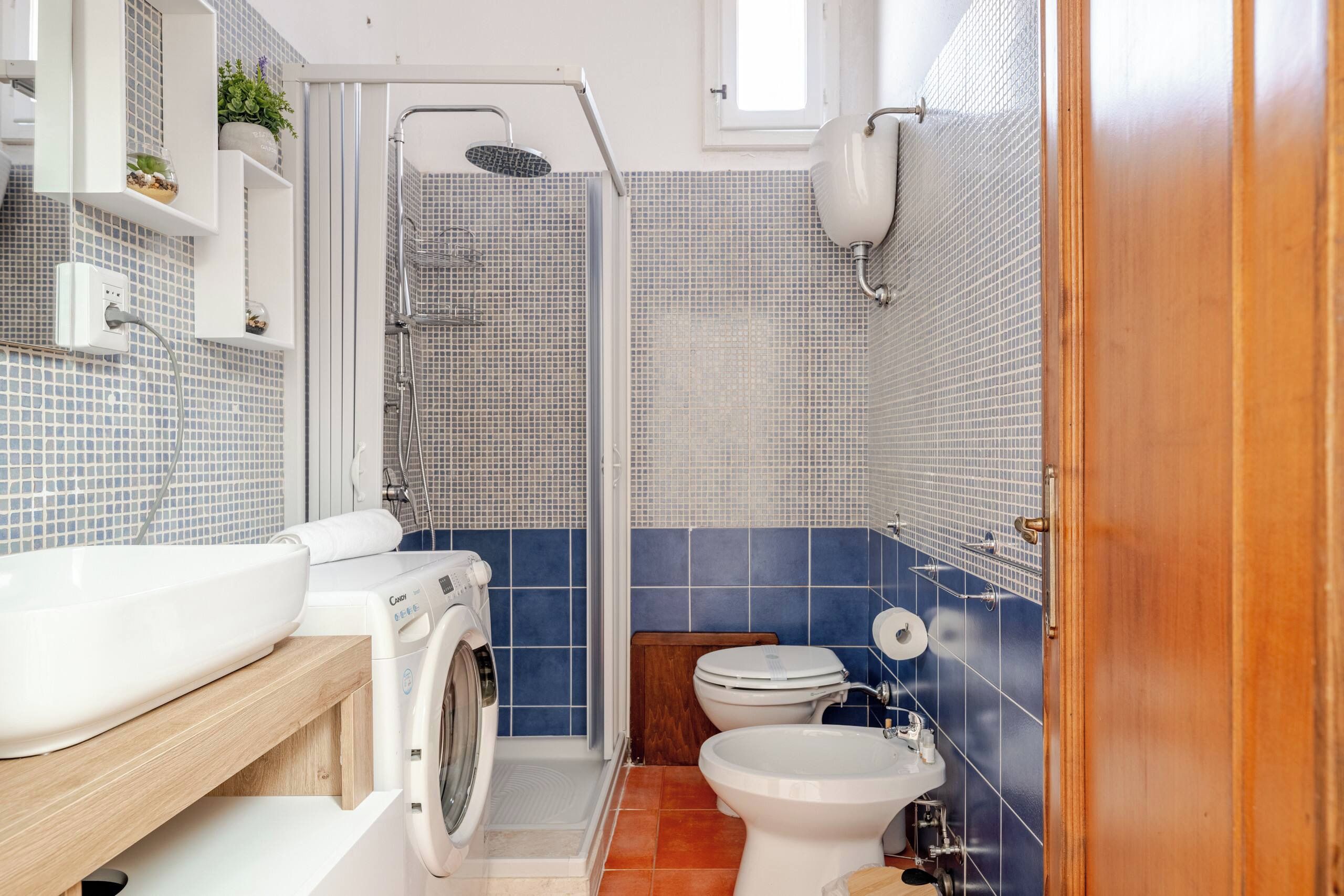 A bathroom with a shower, toilet, and sink.