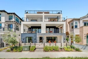 Ein modernes Mehrfamilienhaus mit Balkon, Garage und gepflegtem Garten.