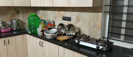 A kitchen with wooden cabinets, a gas stove, and various kitchen utensils.