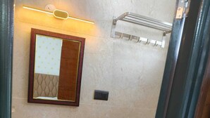 A bathroom with a pedestal sink, a mirror, a towel rack, and a shower. - orange elite stays white field (Bengaluru)