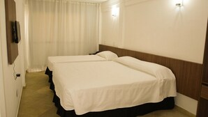A hotel room with two beds, a television on the wall, and a curtain. - Hotel Waikiki Natal (Natal)