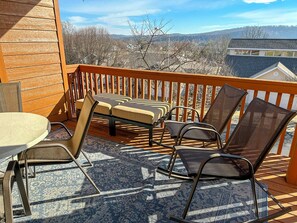 A wooden deck with a table and chairs, a patterned rug, and a view of a mountainous landscape. - Welcome to Royale Retreat at Pointe Royal, in Branson, Missouri! (Branson)