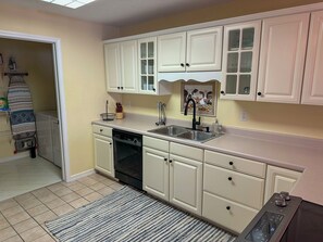 A kitchen with white cabinets, a dishwasher, a sink, and a stove. - Welcome to Royale Retreat at Pointe Royal, in Branson, Missouri! (Branson)