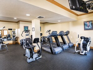 Ein Fitnessstudio mit Laufbändern, Crosstrainern und Ergometer.