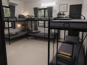 A bunk bed room with a desk, a chair, a potted plant, and a motivational quote on the wall.