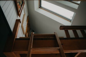 A wooden staircase leading to a room with a skylight. - Petit Lodge | Ski-In/Ski-Out Tremblant (Mont-Tremblant)