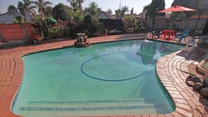 Una piscina rectangular con una línea de agua azul cristalina, rodeada por un borde de ladrillo.