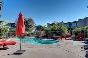 A swimming pool area with red lounge chairs and a red umbrella. - Old Town Scottsdale, Covered Parking, Pool, Sleeps 6 (Scottsdale)