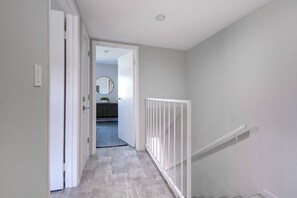 A hallway with a white door, a white railing, and a view into another room. - Old Town Scottsdale, Covered Parking, Pool, Sleeps 6 (Scottsdale)