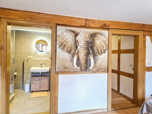 Ein Badezimmer mit einem Holzkosmetikschrank, einem Spiegel und einem Waschbecken.