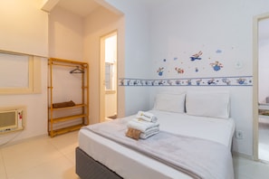 Ein Hotelzimmer mit einem Bett, einem Holzregal, einem Wandheizgerät und einem Fenster.