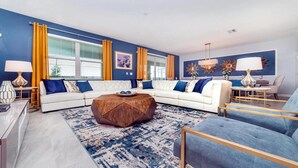 Una sala de estar moderna con un sofá modular, una mesa de centro y un sillón azul.