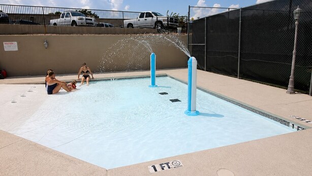 A swimming pool with water jets, a lifeguard tower, and a fence. - Welcome to Relaxation Pointe at Pointe Royale in Branson, Missouri! (Branson)