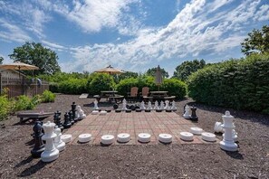 A chessboard set up outdoors with a garden and patio area in the background. - Welcome to Relaxation Pointe at Pointe Royale in Branson, Missouri! (Branson)