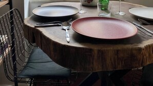 A dining table set with plates, cutlery, and glasses, positioned by a window with a view of buildings. - Redecorated Flat With Huge Library 100mbps (Istanbul)