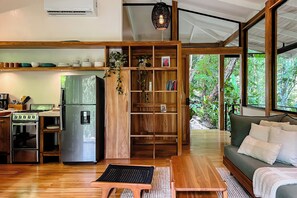 Una cocina moderna con refrigerador, estufa y estantes de madera.