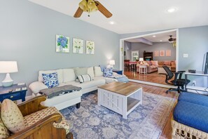 Ein Wohnzimmer mit einer Couch, einem Couchtisch und einem Essbereich mit Tisch und Stühlen.