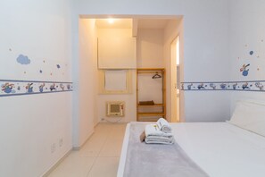 A hotel room with a bed, a towel, a wardrobe, and a small window. - 5 min From Copacabana Beach Sf404 (Rio de Janeiro)