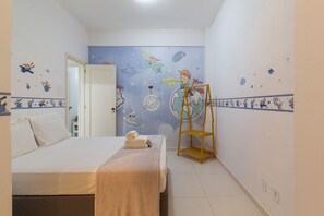 Ein Schlafzimmer mit einem Bett, einer Holzleiter und einer Wand mit Wandbildern zum Thema Weltraum.