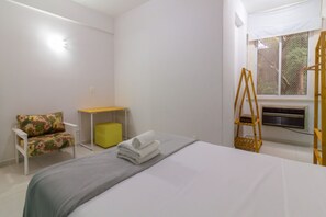 Ein Schlafzimmer mit einem Bett, einem Sessel, einem kleinen Tisch und einem Fenster mit Blick.