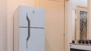 Una cocina con un refrigerador blanco, una estufa y una puerta con un diseño metálico decorativo.