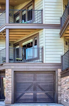 A multi-story residential building with a garage, balconies, and a number '14' on the garage door. - Elevated Oasis-3BR-Mt. CB-Garage-Hot Tub-Mountain Views (Crested Butte)