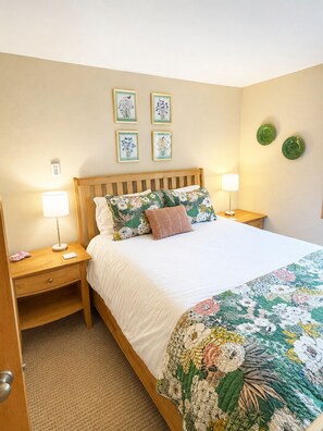 A bedroom with a wooden bed, two bedside lamps, a nightstand with a drawer, and a carpeted floor. - Elevated Oasis-3BR-Mt. CB-Garage-Hot Tub-Mountain Views (Crested Butte)