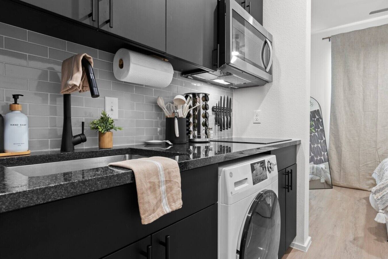 A modern kitchen with a built-in dishwasher, a microwave, and a variety of utensils and appliances.
