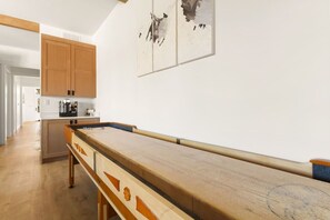 A kitchen with wooden cabinets, a long wooden table, and a painting on the wall. - Rooftop Views, Walk to Downtown, Sleeps 13 (Buena Vista)