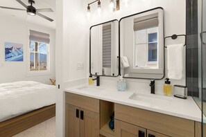 A modern bathroom with a double vanity, a ceiling fan, and a large mirror. - Rooftop Views, Walk to Downtown, Sleeps 13 (Buena Vista)