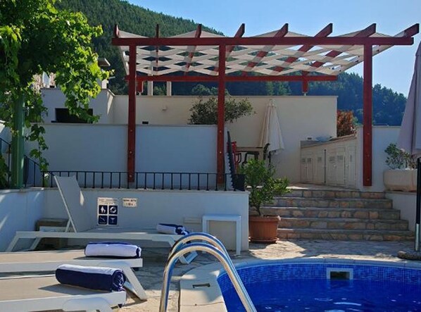 A pool area with lounge chairs, a pergola, and a staircase leading to a building. - Panoramic View Relax Villa Smoquizza (Smokvica)