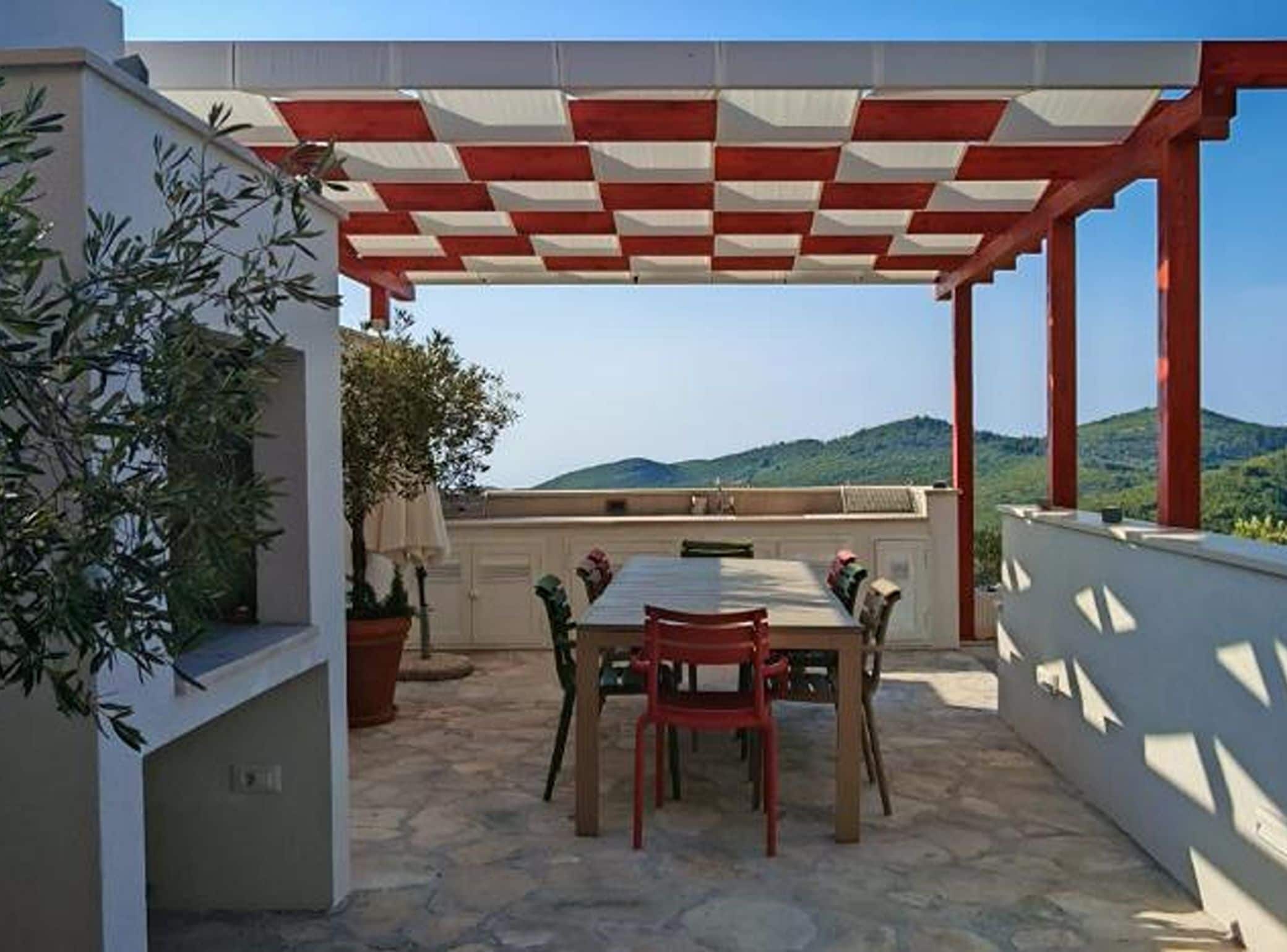 An outdoor patio with a checkered roof, a table, and chairs.