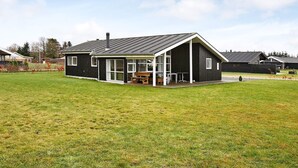 A modern two-story house with a large front lawn and a dining area. - 4 Star Holiday Home in Hadsund (Hadsund)
