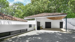 A modern building with a tiled roof, white walls, and a gravel driveway. - Family Home with Private Pool – 5 Min drive to the Beach (Tamarindo)