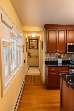 A kitchen with wooden cabinets, a microwave, and a stove. - Beautiful, Charming and Private house close to EVERYTHING. A/C and Fast Wifi (Orford)