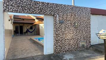 Un immeuble résidentiel à l’extérieur recouvert de carreaux, doté d’une piscine et d’un patio couvert.