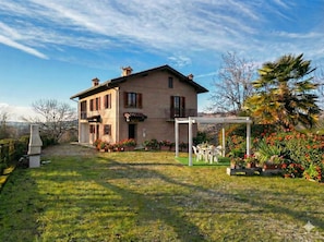 A two-story house with a covered patio area. - Villa with a garden in the heart of Monferrato (Piemonte)