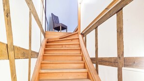 Un escalier en bois avec une chaise en haut.